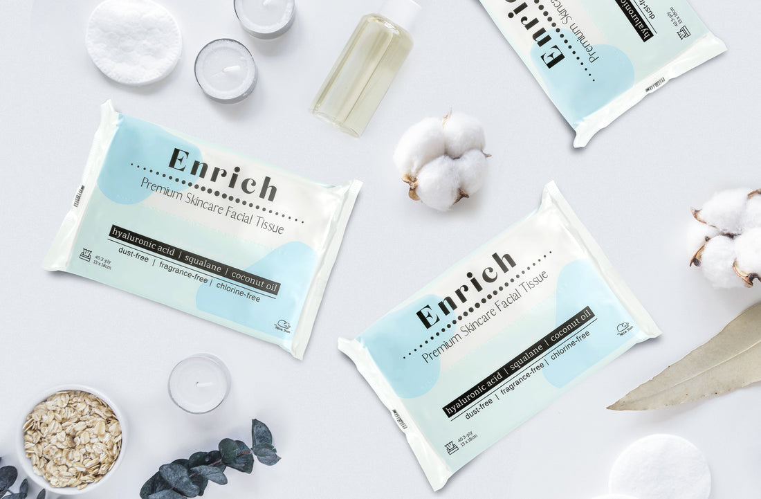 Enrich premium skincare facial tissue pack with hyaluronic acid, squalane and coconut oil, styled with skincare serum and natural leaves