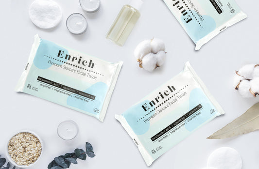 Enrich premium skincare facial tissue pack with hyaluronic acid, squalane and coconut oil, styled with skincare serum and natural leaves
