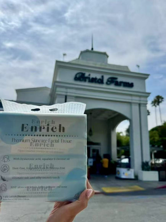 Enrich premium skincare facial tissue family pack held in front of Bristol Farms supermarket entrance